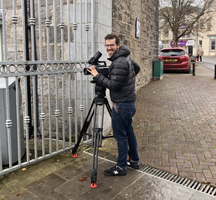Media camera man setting lens for filming.