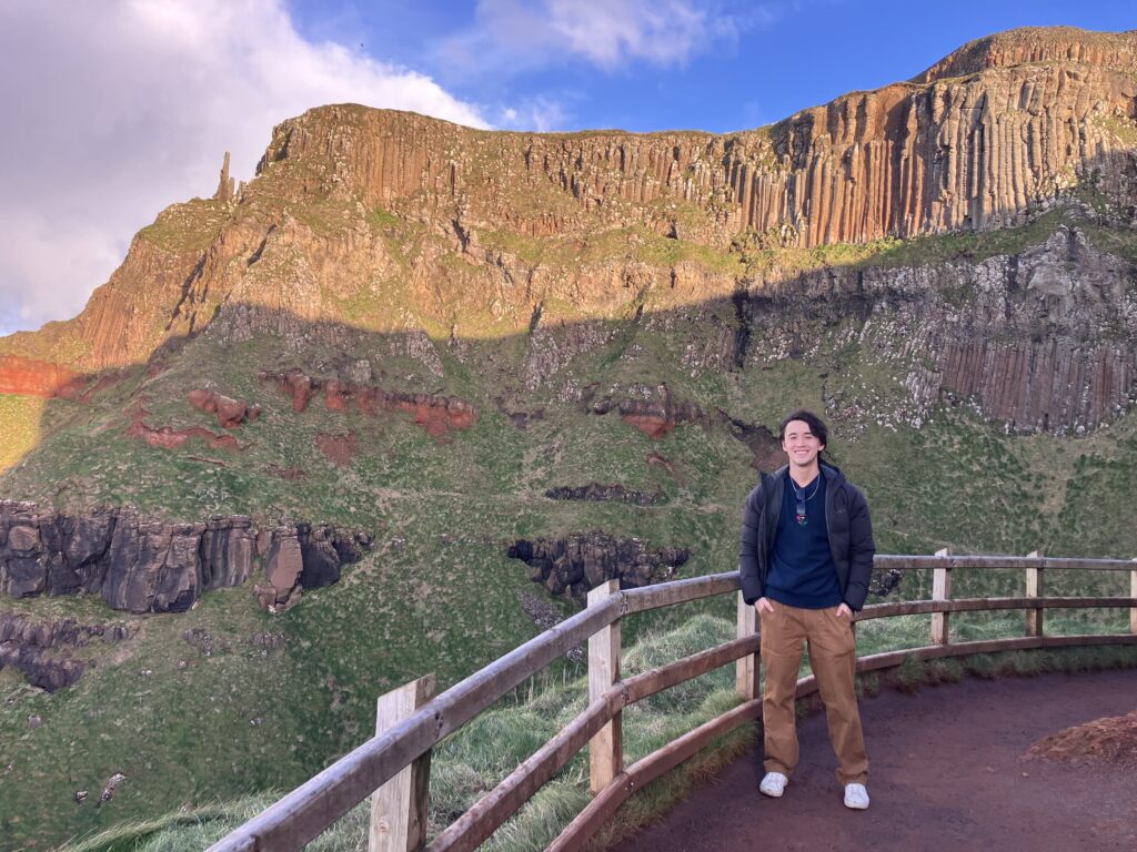 "Scenic views of the Amphitheatre at the Giant Causeway, Northern Ireland, featuring dramatic basalt columns and lush coastal cliffs at golden hour. A signiture stop on Diamond Chauffeurs Ireland's guided tours for Belfast Cruise passengers."